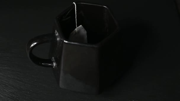 Carro de té de karkade vertido agua hirviendo sobre un fondo oscuro primer plano 4k — Vídeo de stock