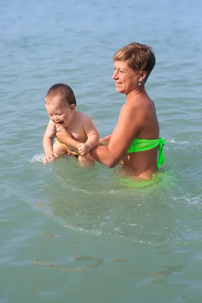 Mom with a baby on the sea, a woman with a child rides on the sea for one year