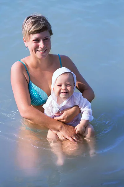 Mom with a baby on the sea, a woman with a child rides on the sea for one year