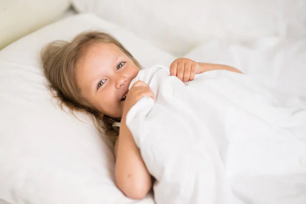 A girl of four years old sleeps in bed