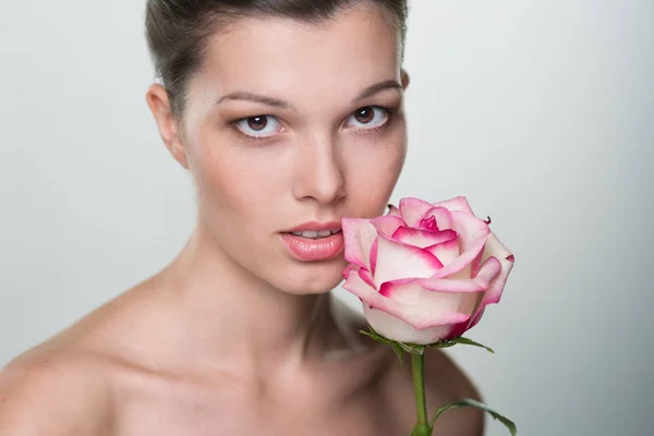 Face of beautiful young woman with rose