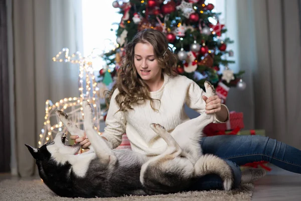 Teen girl with dog in a room decorated for Christmas