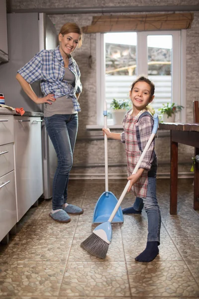Mom and daughter are cleaning in the apartment, a woman and a girl doing household chores