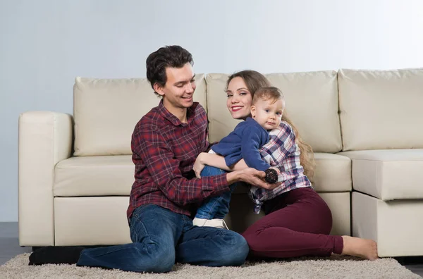 Familia Con Un Bebe En Una Habitacion Con Un Sofa Mama Y Papa Y Un Nino De Un Ano Hija Chica Stock Photo Familia Con Un Bebe En Una Habitacion Con Un Sofa Mama Y Papa Y Un Nino De Un Ano Hija Chica Stock Photo