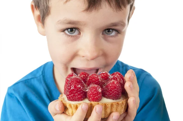 白で隔離のフルーツ ケーキを食べる少年 — ストック写真