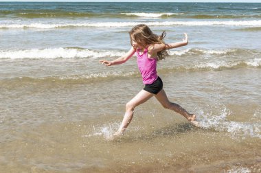 Kumsalda oynayan küçük kız.