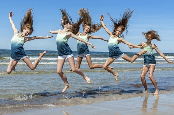 Group girls jumping on the beach