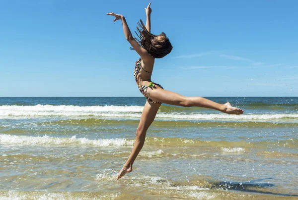 Beautiful girl jumping on the beach — Stock Photo, Image