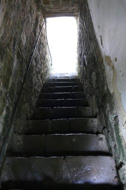 Eski bir binada taş merdiven. Arka aydınlatma. Tırman.