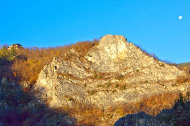 Bir taş ev. Güneş yükseliyor.