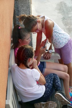Gabrovo, Bulgaristan, 15 Temmuz 2018. Çocuk oyun. Üç kızlar 10-12 yıl yaşlı kız bir bankta oturup. Tatil, yaz.