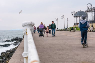 Köstence, Romanya. 19 Nisan 2019. Soğuk, karanlık Bir Nisan günü. Turistler sahil bulvarı boyunca yürürler. Köstence Karadeniz üzerinde önemli bir liman kenti yanı sıra popüler bir turizm.