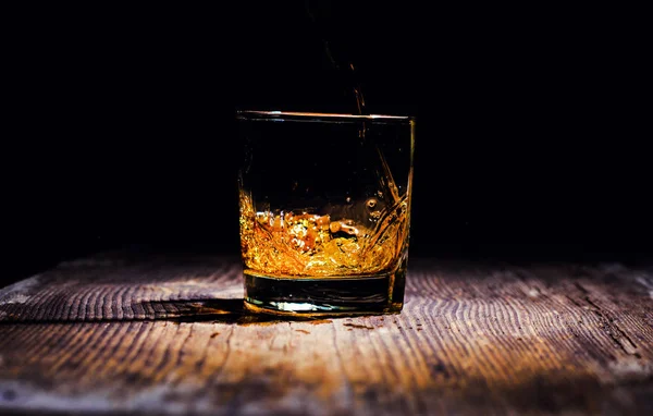 Whisky med isbitar på trä bakgrund — Stockfoto