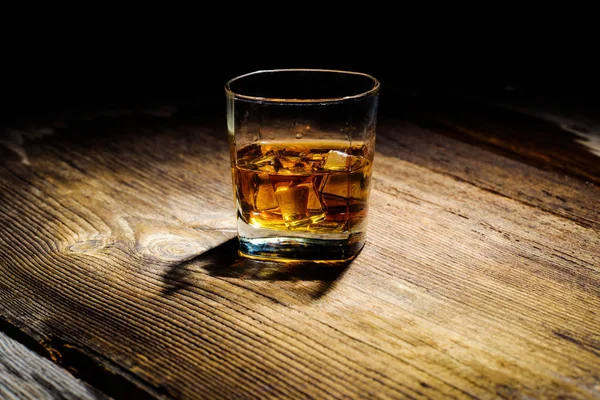 Isolated shot of whiskey with splash on black background — Stock Photo, Image