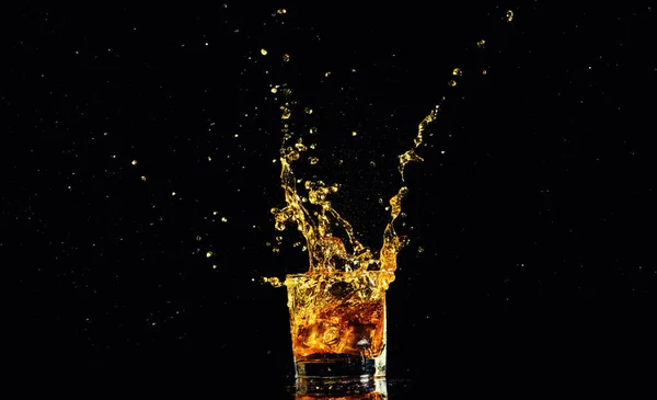 Colpo isolato di whisky con spruzzata su sfondo nero — Foto Stock