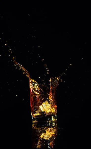 Isolated shot of whiskey with splash on black background — Stock Photo, Image