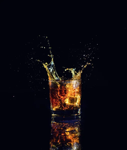 Geïsoleerde shot whisky met splash op zwarte achtergrond — Stockfoto