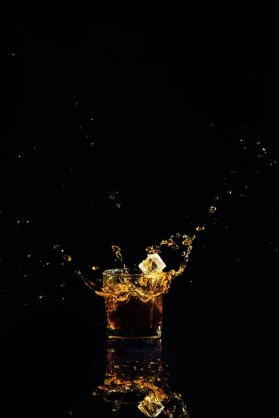 Colpo isolato di whisky con spruzzata su sfondo nero — Foto Stock