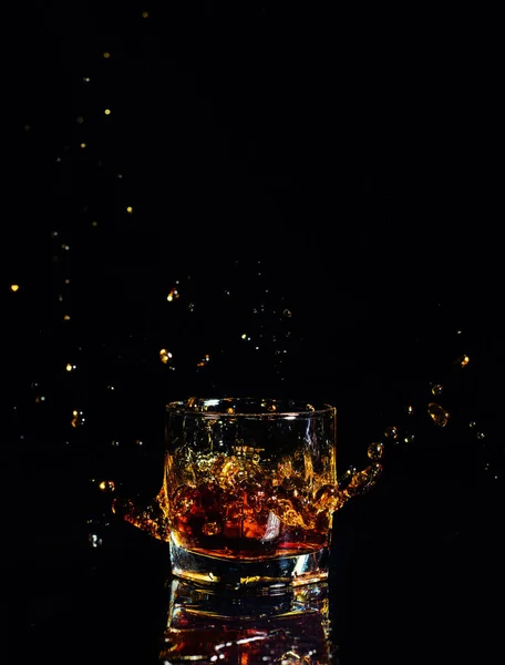 Isolierter Schuss Whisky mit Spritzer auf schwarzem Hintergrund — Stockfoto