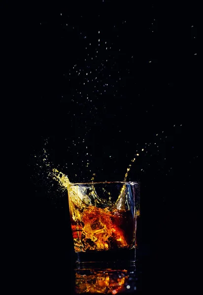 黒の背景にスプラッシュとウイスキーの分離ショット ブランデーします。 — ストック写真