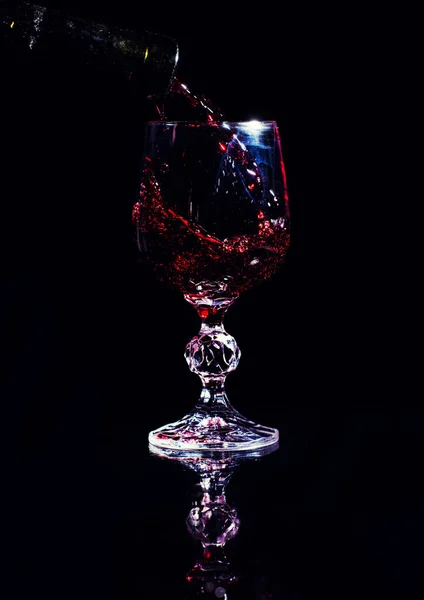 Червоне вино вливається в келих для вина — стокове фото
