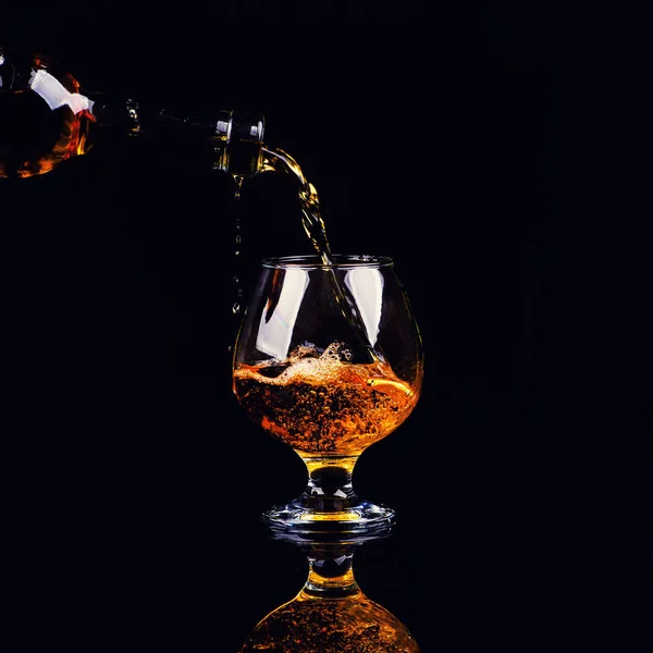 Verre avec cognac sur fond noir — Photo