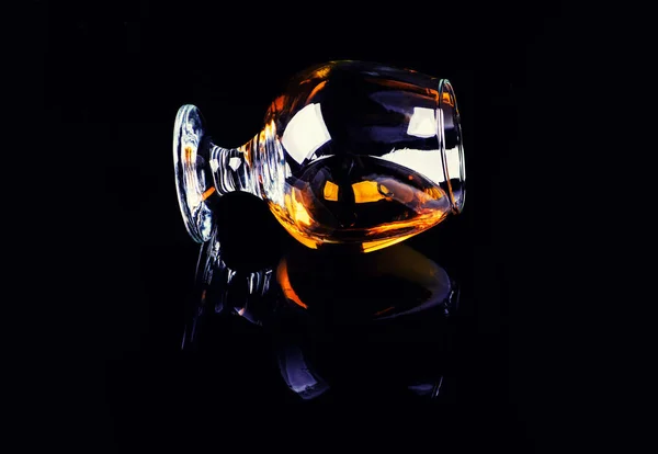 Kaca dengan cognac pada latar belakang hitam — Stok Foto