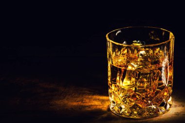 Arkaplanda buz küpleri olan viski.