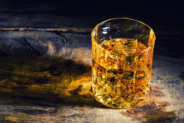 Whiskey with ice cubes on wooden background — Stock Photo, Image