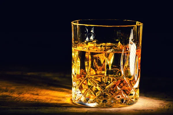 Whiskey with ice cubes on wooden background — Stock Photo, Image