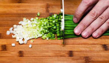 Yemek. Şef mutfakta yeşil soğan kesiyor