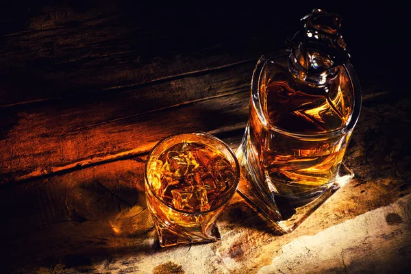 Whiskey with ice cubes on wooden background — Stock Photo, Image