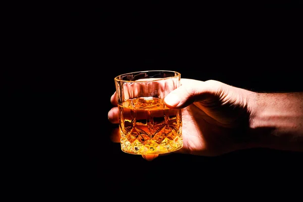 Un vaso de whisky en la mano de un hombre —  Fotos de Stock