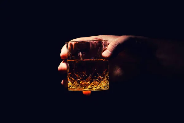 Un vaso de whisky en la mano de un hombre —  Fotos de Stock