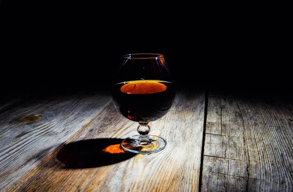 Vetro con cognac su fondo di legno — Foto Stock