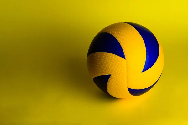 Волейбольний м'яч на жовтому фоні . — стокове фото