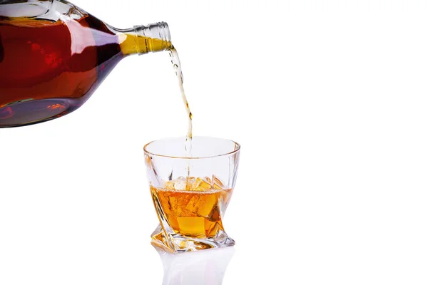 Виски с брызгами на белом фоне, бренди в стакане — стоковое фото