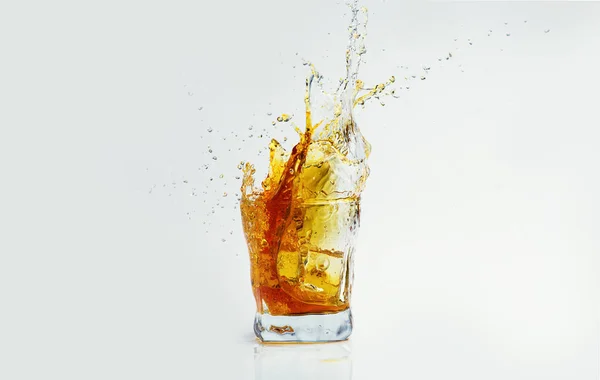 Whiskey with splash on white background, brandy in a glass