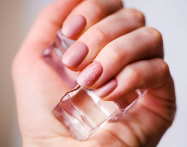 Diseño de uñas. Manos con manicura rosada brillante de la primavera en Bac gris — Foto de Stock