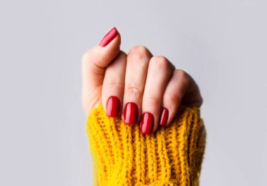 Çivi Tasarım. Gri Sırt parlak kırmızı bahar manikür ile Eller