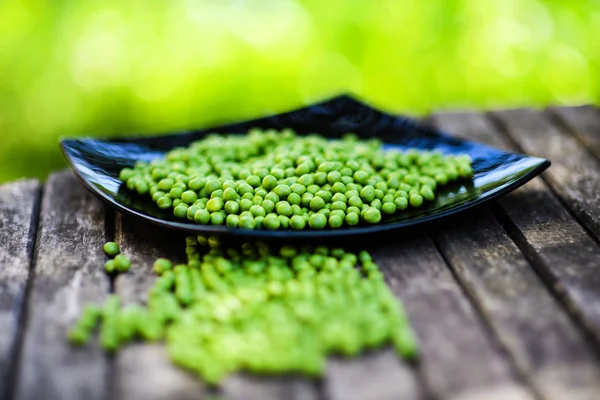 Ervilhas verdes em fundo de madeira. Comida saudável. Estilo rústico escuro — Fotografia de Stock