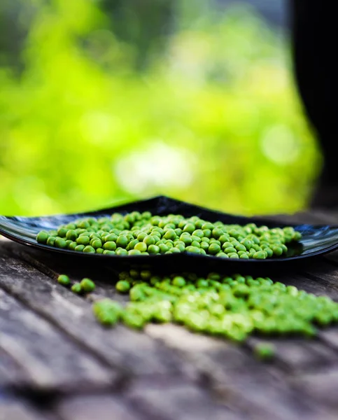 Guisantes verdes sobre fondo de madera. Comida saludable. Estilo rústico oscuro —  Fotos de Stock