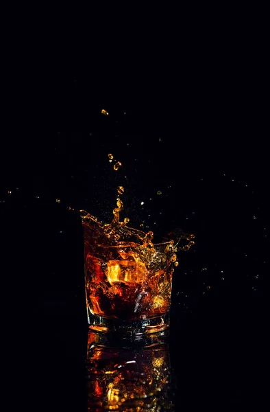 Isolerad bild av whisky med stänk på svart bakgrund — Stockfoto