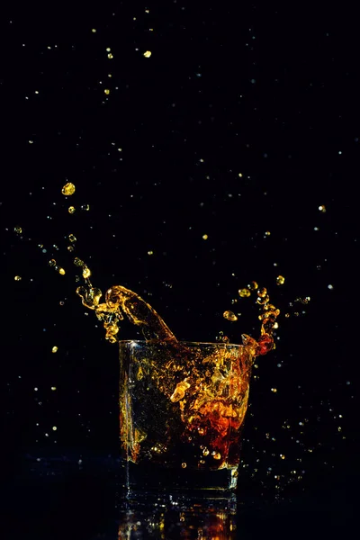 Colpo isolato di whisky con spruzzata su sfondo nero — Foto Stock