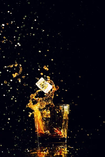 Tiro aislado de whisky con salpicadura sobre fondo negro — Foto de Stock