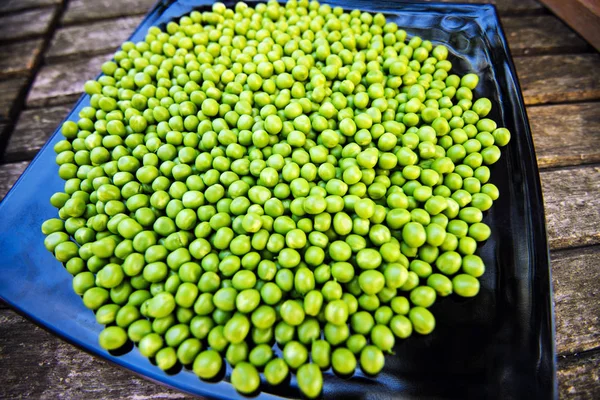 Green peas on wooden background — Stock Photo, Image