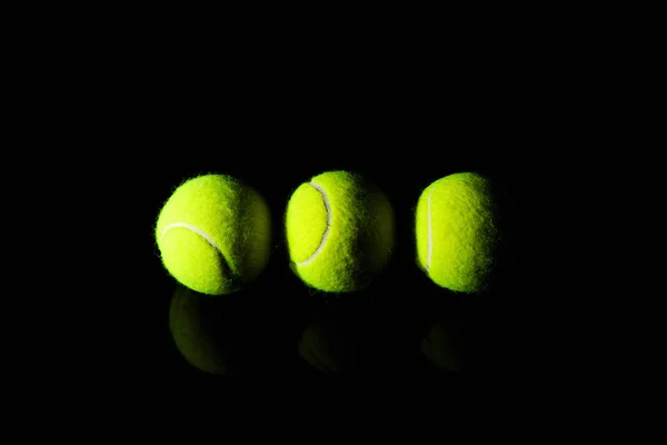 Tenis topu siyah dramatik aydınlatma ile izole — Stok fotoğraf