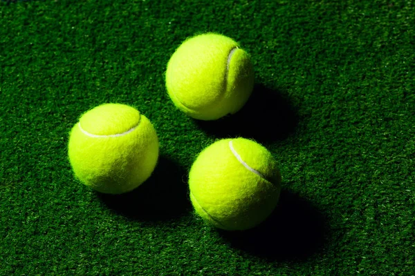 Tennis Ball isolated on green with dramatic lighting — Stock Photo, Image
