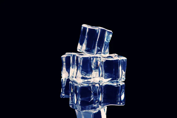 Ice cubes on reflection table on black background — Stock Photo, Image