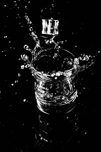 Isolated shot of whiskey with splash on black background — Stock Photo, Image